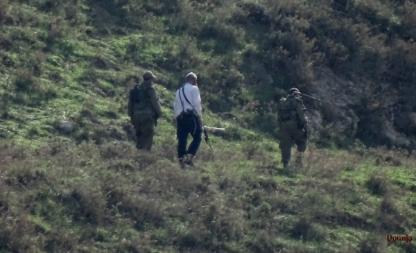 1 illegal settler hiking on the hills around Madama, accompanied by 2 israeli soldiers.