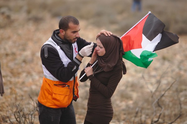 A woman receives medal assistance in Nabi Saleh