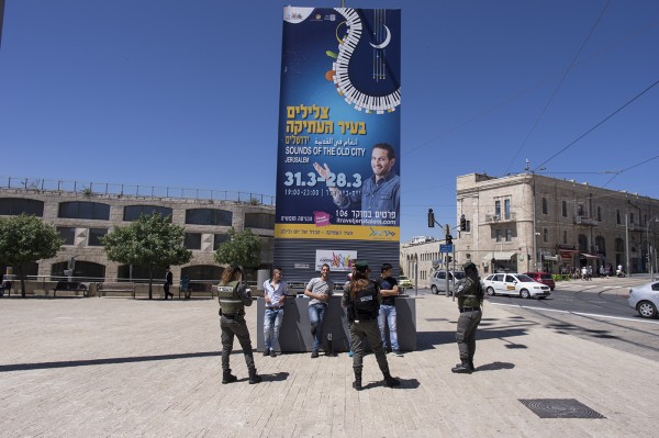 Young men are stopped, apparently at random, to be searched on the outskirts of the old city.