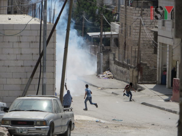 Children running away from tear gas shot by Israeli Forces at Salaymeh checkpoint
