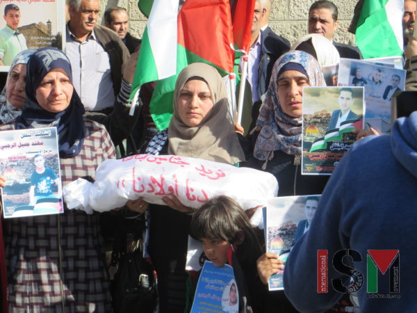 Women holding signs of their killed family members