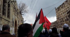 Palestinians marching towards a gate that closes off Shuhada Street, Feb 22, 2019