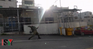 Soldier throwing concussion grenade at children