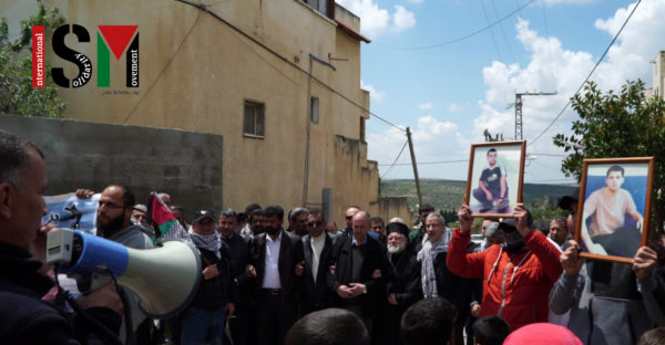 Protesters gathered, picture of martyr, orthodox priest