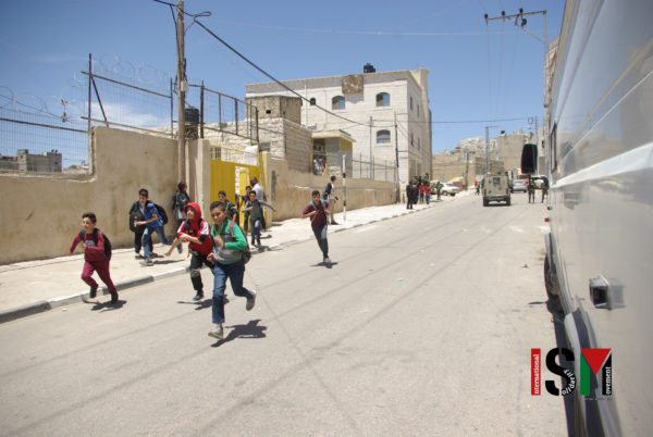 children running away, military jeep in the background