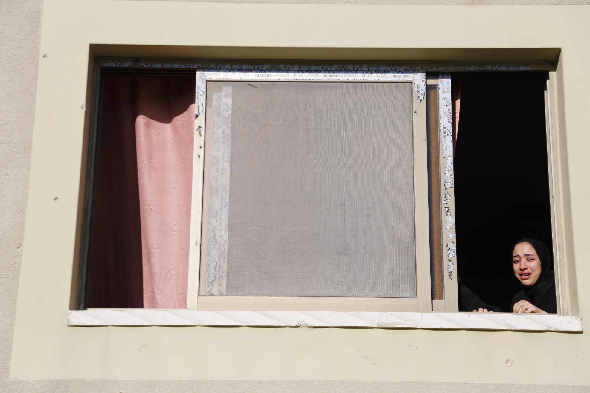 A resident of Nour Shams Camp looks out of her window after the Israeli attack