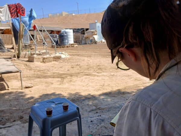 A volunteer writes in a notebook in a Palestinian village.