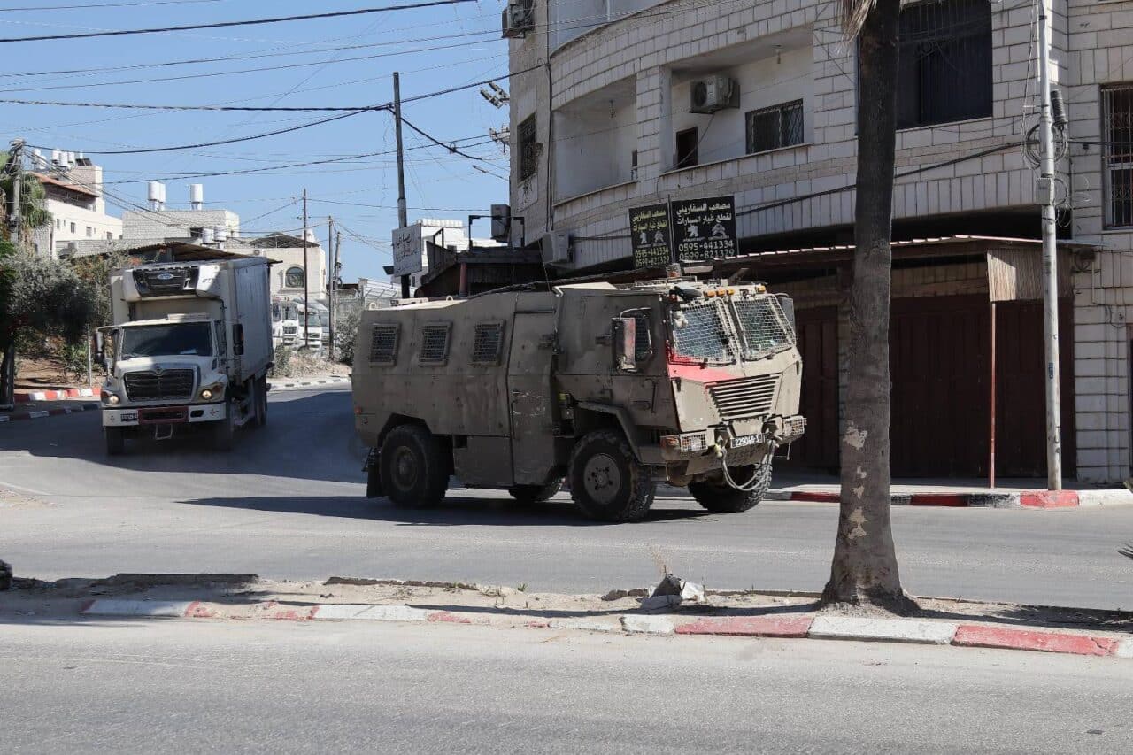 A tank drives down a residential street