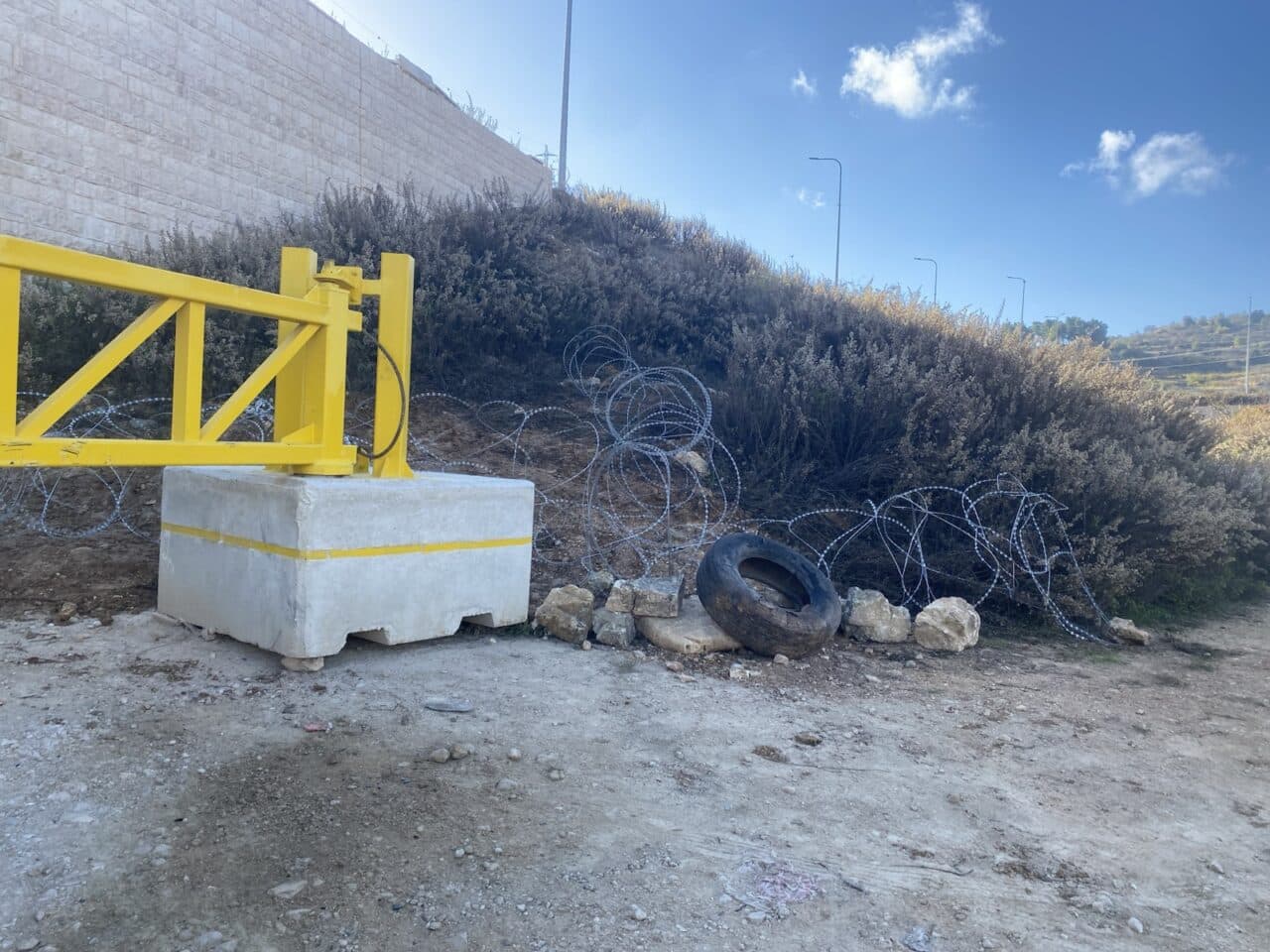 Photo: Road barricades including metal and brick fences and razor wire block Palestinians' path to their land in Halhul